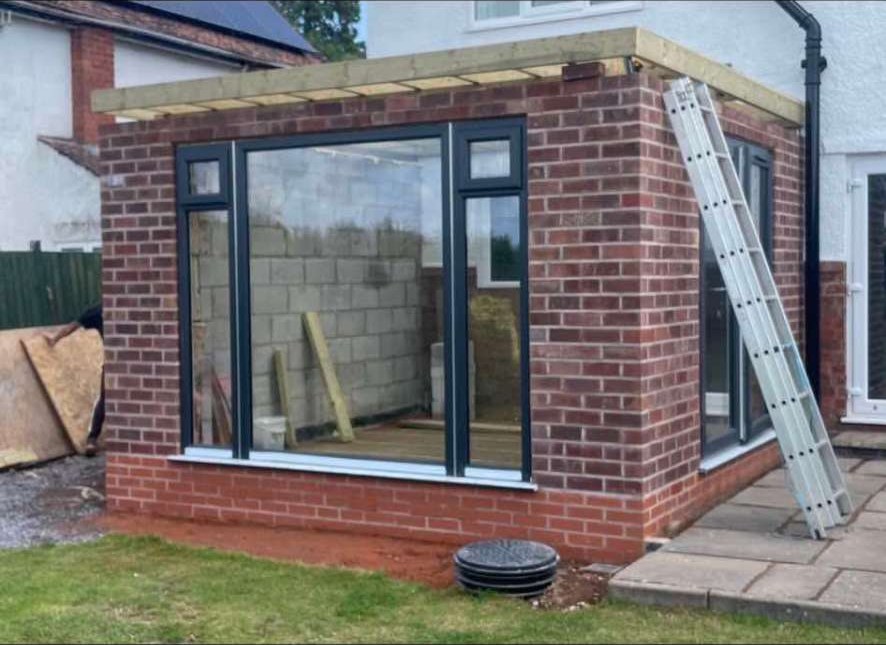 Newly built brick garden room extension with grey aluminium windows