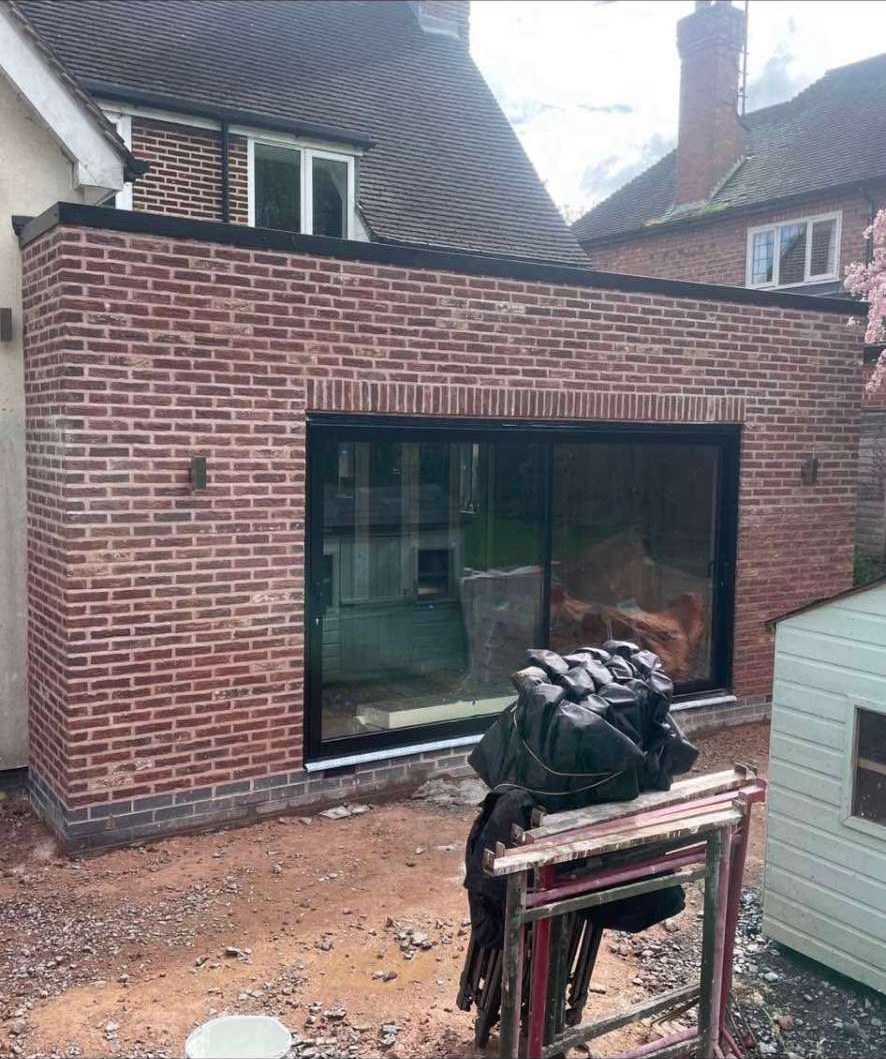 Rear brick extension with large sliding doors and soldier course detail