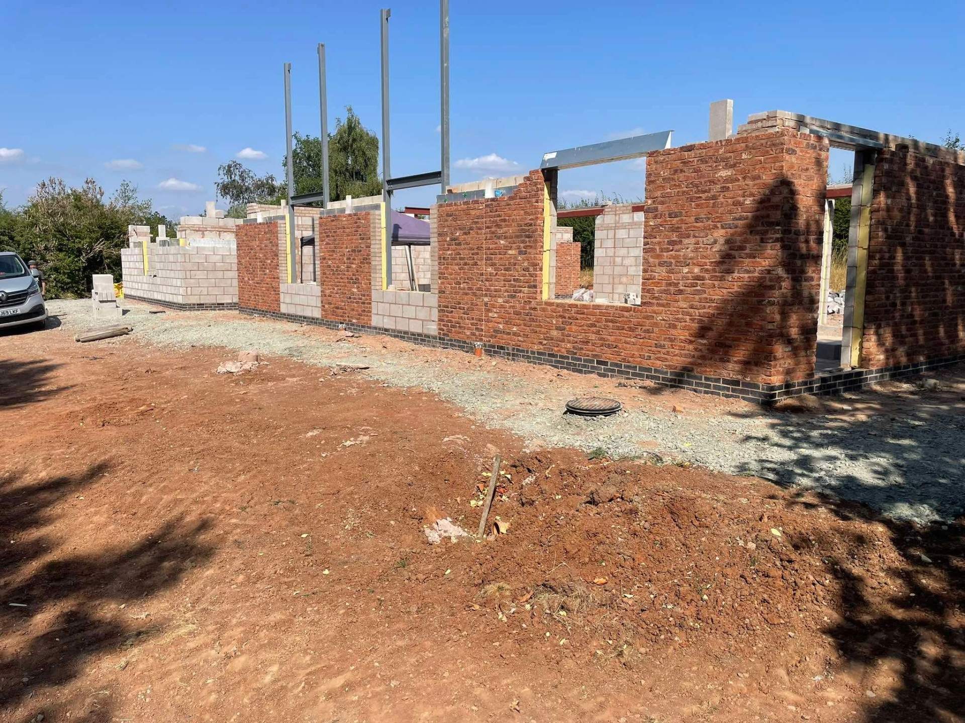 Reclaimed brick and blockwork walls rising on a new build