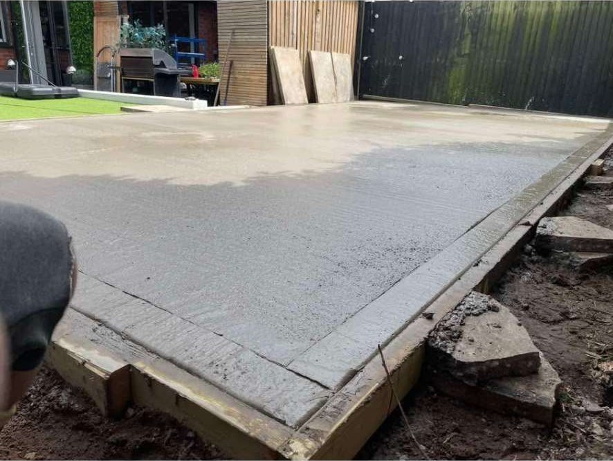 Freshly poured and tamped concrete base in a rear garden